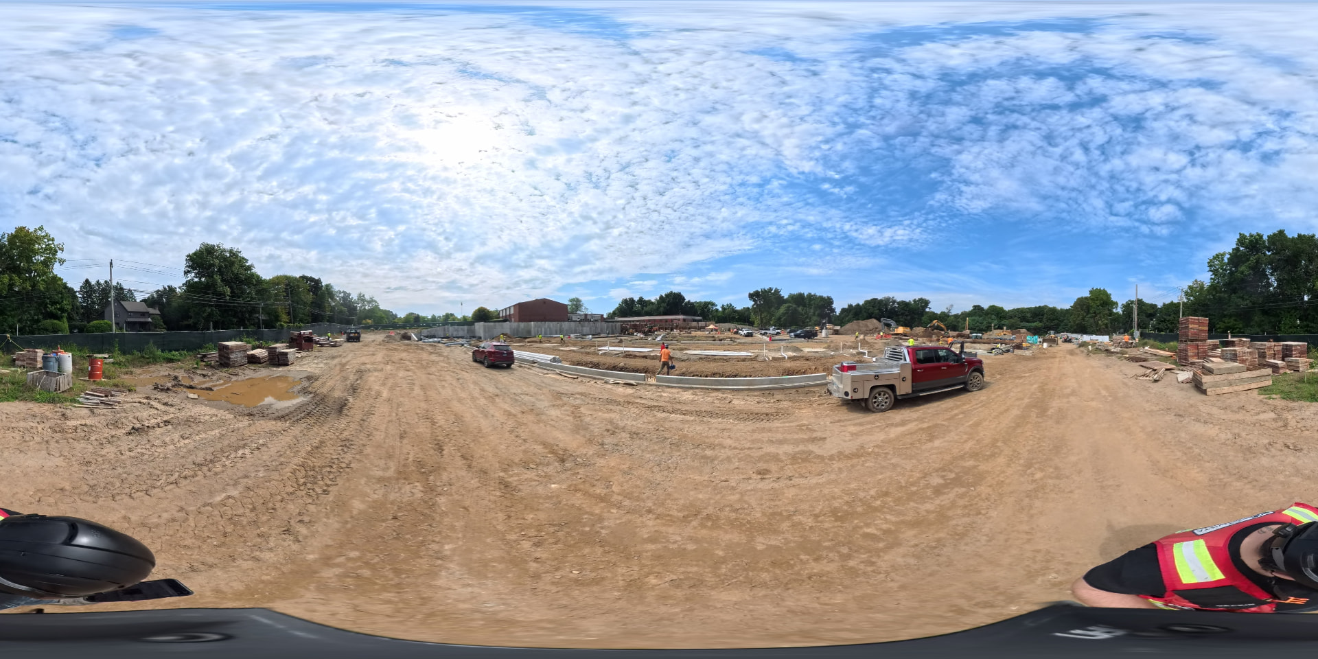 September 2026 — Full-site panorama showing the graded construction road, foundation perimeter and equipment staged across the building footprint